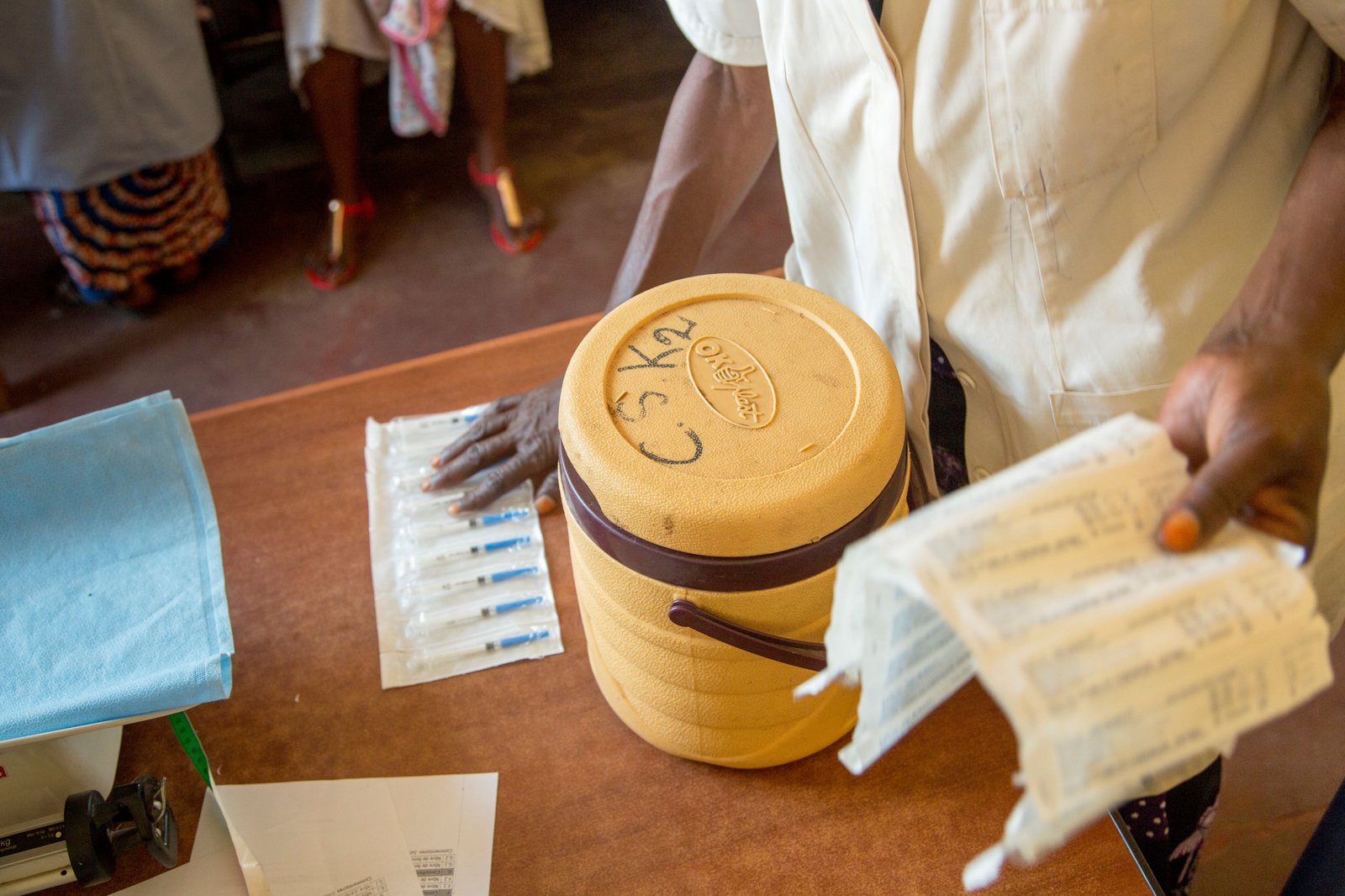 Photo: A health care worker unpacks a container full of vaccine vials at Kenya General Hospital in Lubumbashi, Democratic Republic of the Congo. Credit: PATH/Georgina Goodwin
