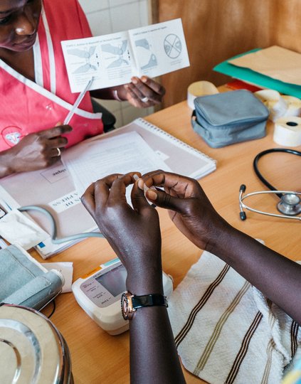 Aminata Gaye, 29, (left) explains to patient Mossan Faye, 21, how to self-inject the contraceptive Sayana Press in Pikine, Senegal. Mossan enrolled in a PATH-led research study in Senegal on self-injection. PATH/Gabe Bienczycki.