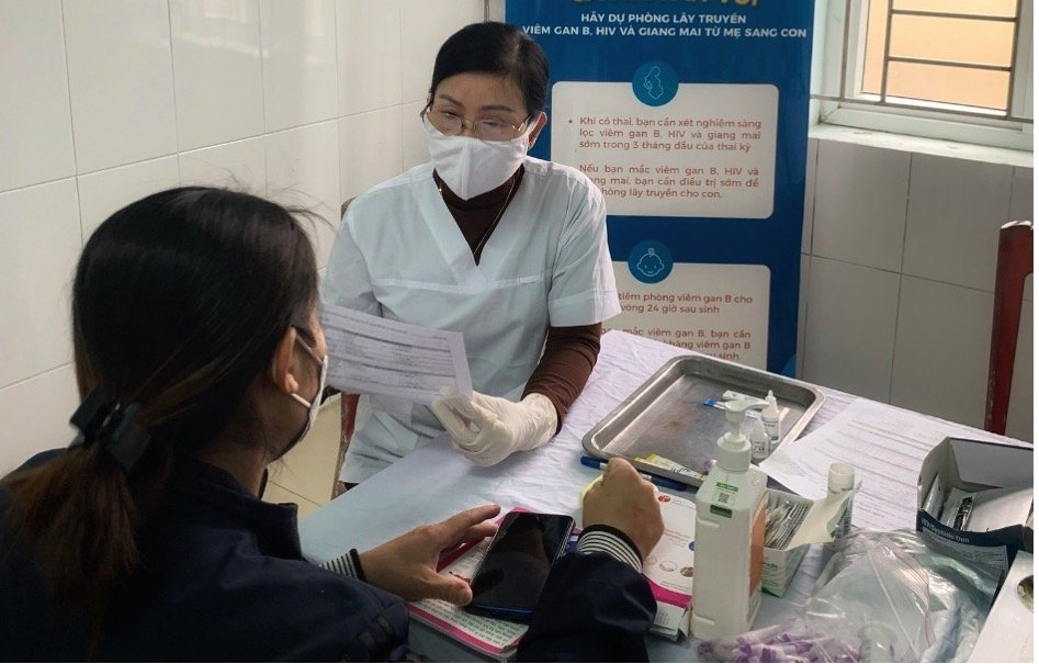 A health care worker speaks with a client about HBV, HIV, and syphilis at Dong Hieu Commune health station in Thai Hoa Town. Photo: Ha Nguyen/PATH.