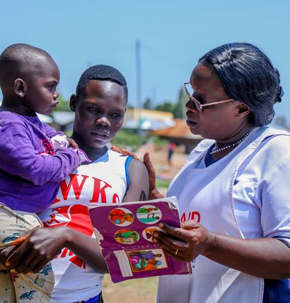 Kendu Bay Sub-County Hospital Vaccines and Immunization Coordinator, Victorine Wasonga (right), speaks with Jane Awuor and her 2-year-old child, Shirley Marion, about the importance of timely childhood vaccination against life-threatening diseases.