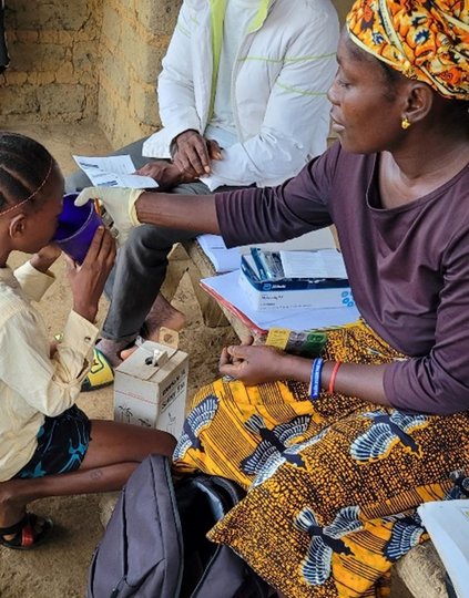 A community health worker administers antimalarial treatment to treat a case of malaria as part of proactive community case management, Pujehun District, Sierra Leone. Photo Credit: PMI Insights